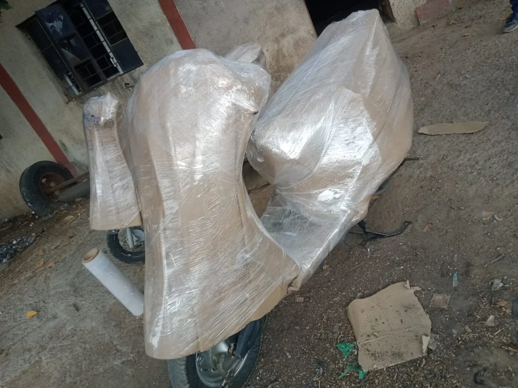 Two-wheeler scooter protected with corrugated cardboard and film